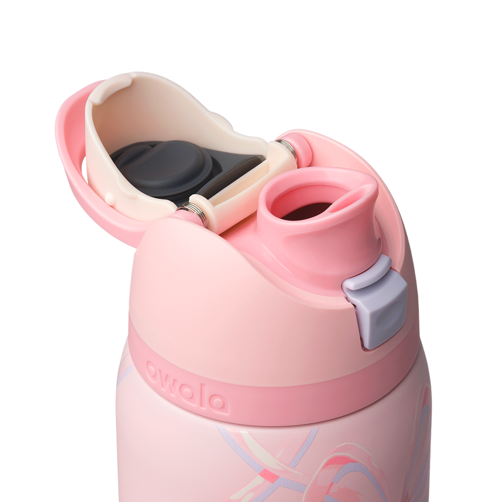 Owala FreeSip 32oz in Sugar Plum Fairy, close-up of pink lid open exposing cream FreeSip spout and lilac push-button against the bow-patterned body
