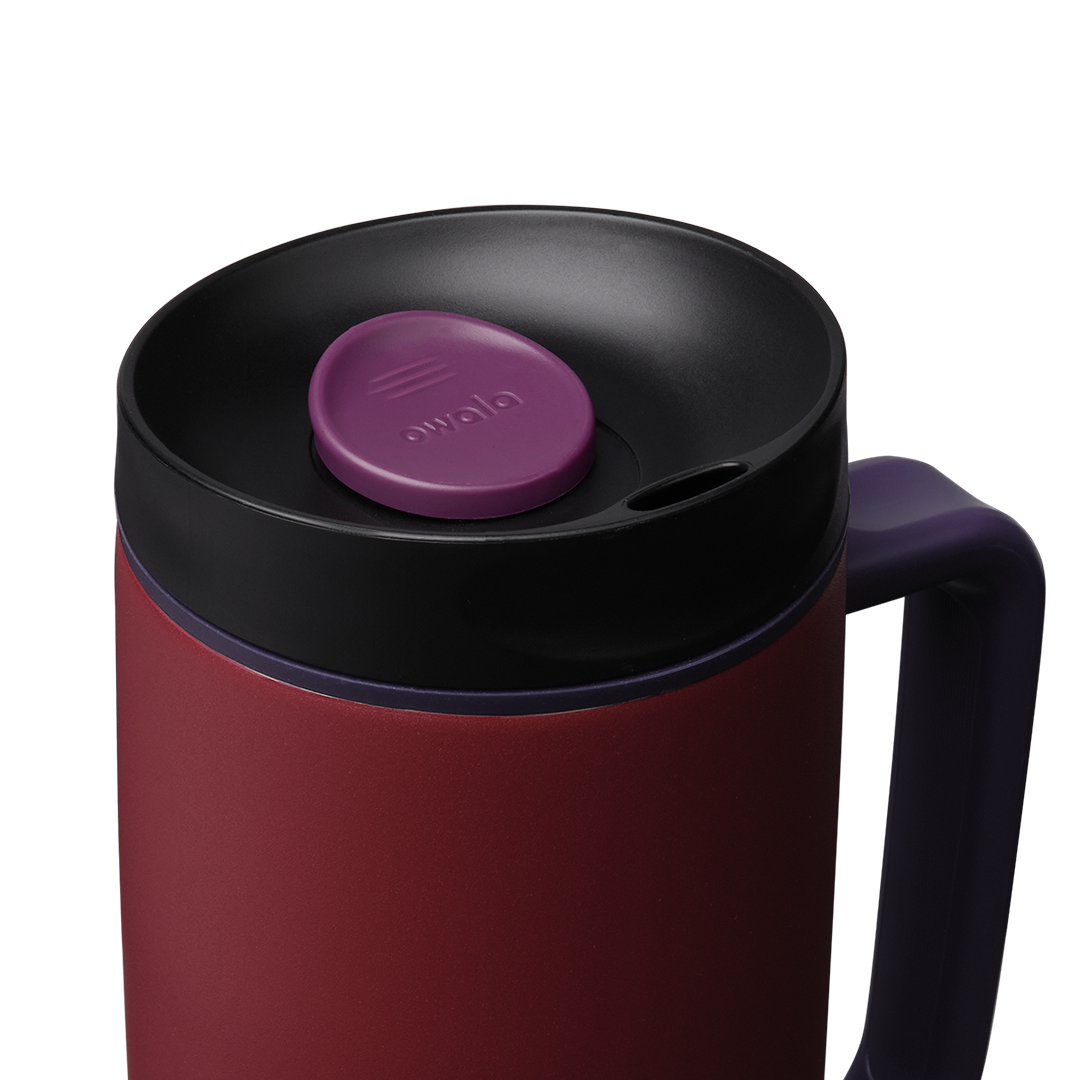Owala SmoothSip Slider with Handle 24oz in Burgundy Bay, close-up of black lid with purple slider button and accent ring above deep crimson body with navy handle